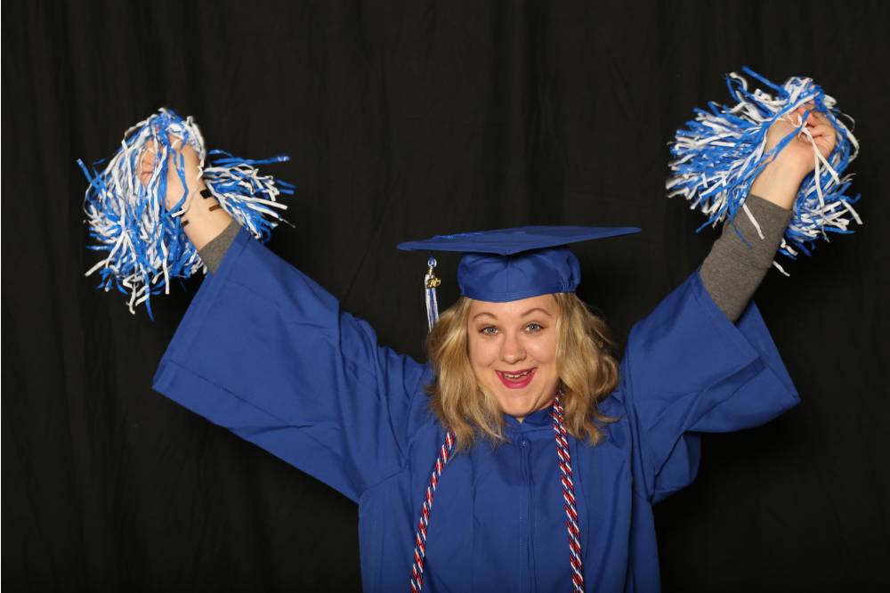soon to be graduate using pom poms as a prop